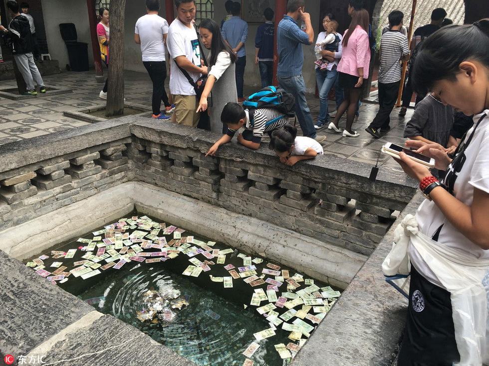 河南洛阳一景区：许愿池游客投币 百元大钞沉水底